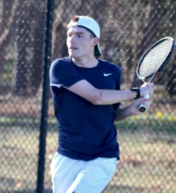 Tennis player hitting backhand on outdoor court